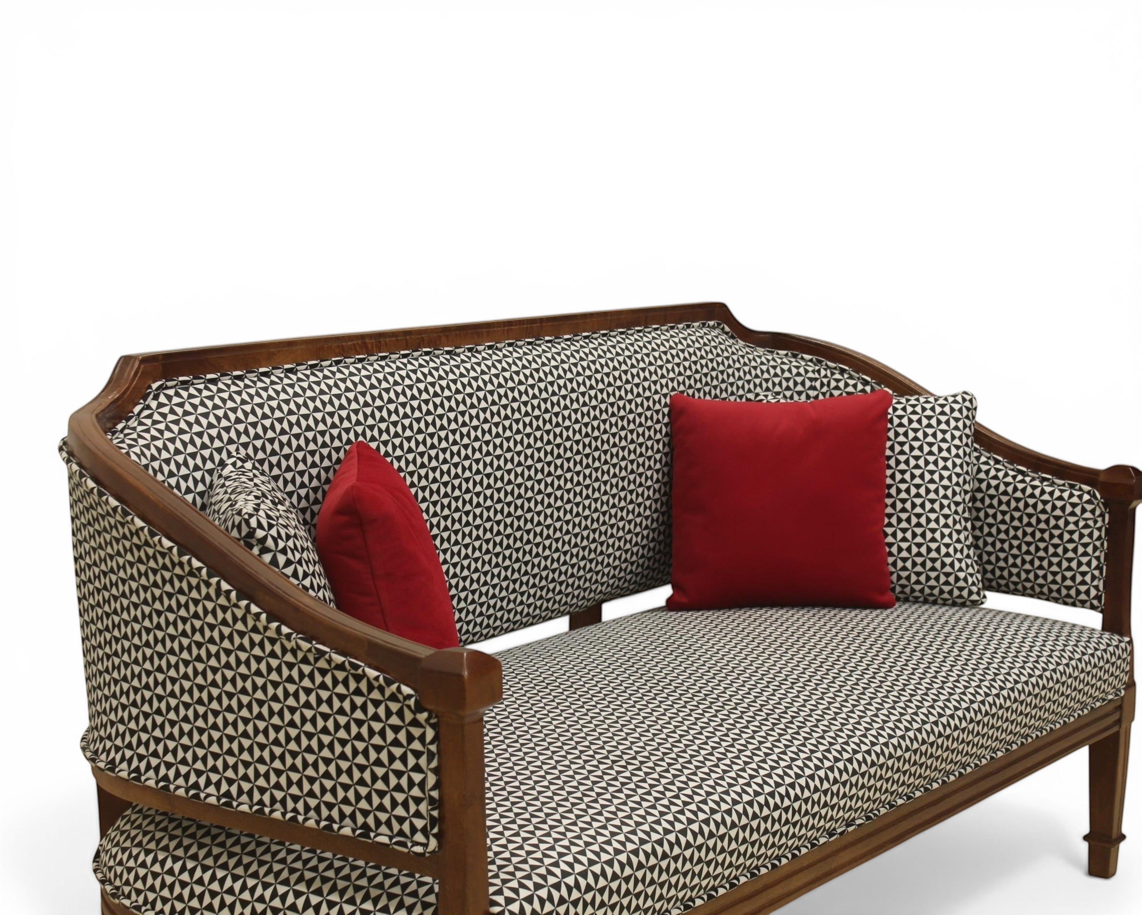 Nakoda Homes classic armchair and sofa set with wooden frame, black and white geometric upholstery, and red accent pillows.