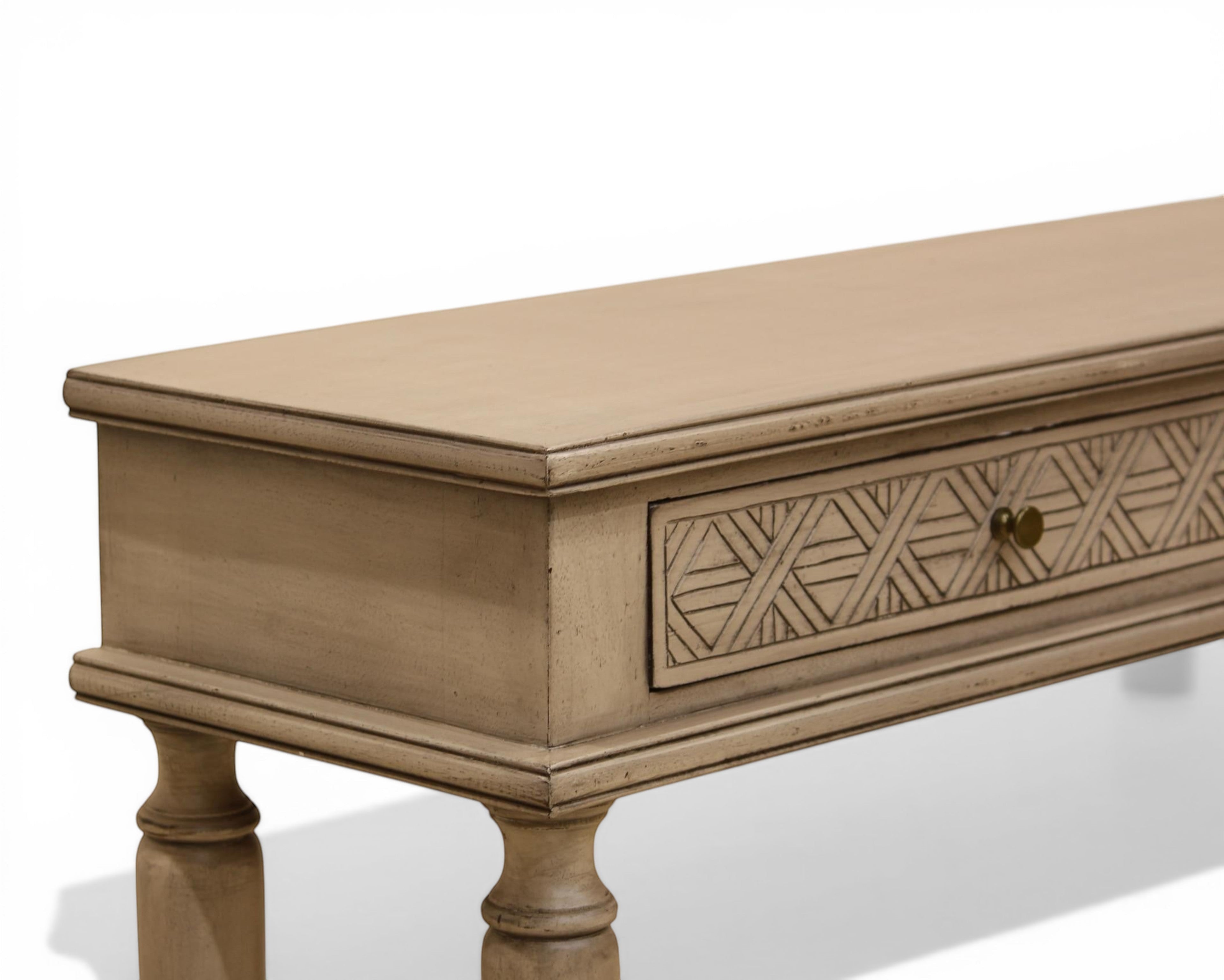 Nakoda Homes distressed grey wood console table with carved geometric drawer fronts and brass knobs.