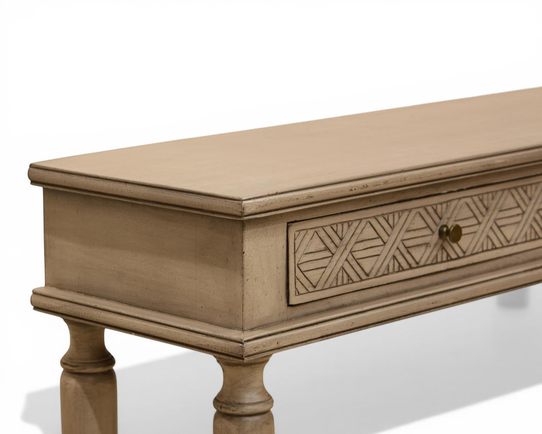 Nakoda Homes distressed grey wood console table with carved geometric drawer fronts and brass knobs.