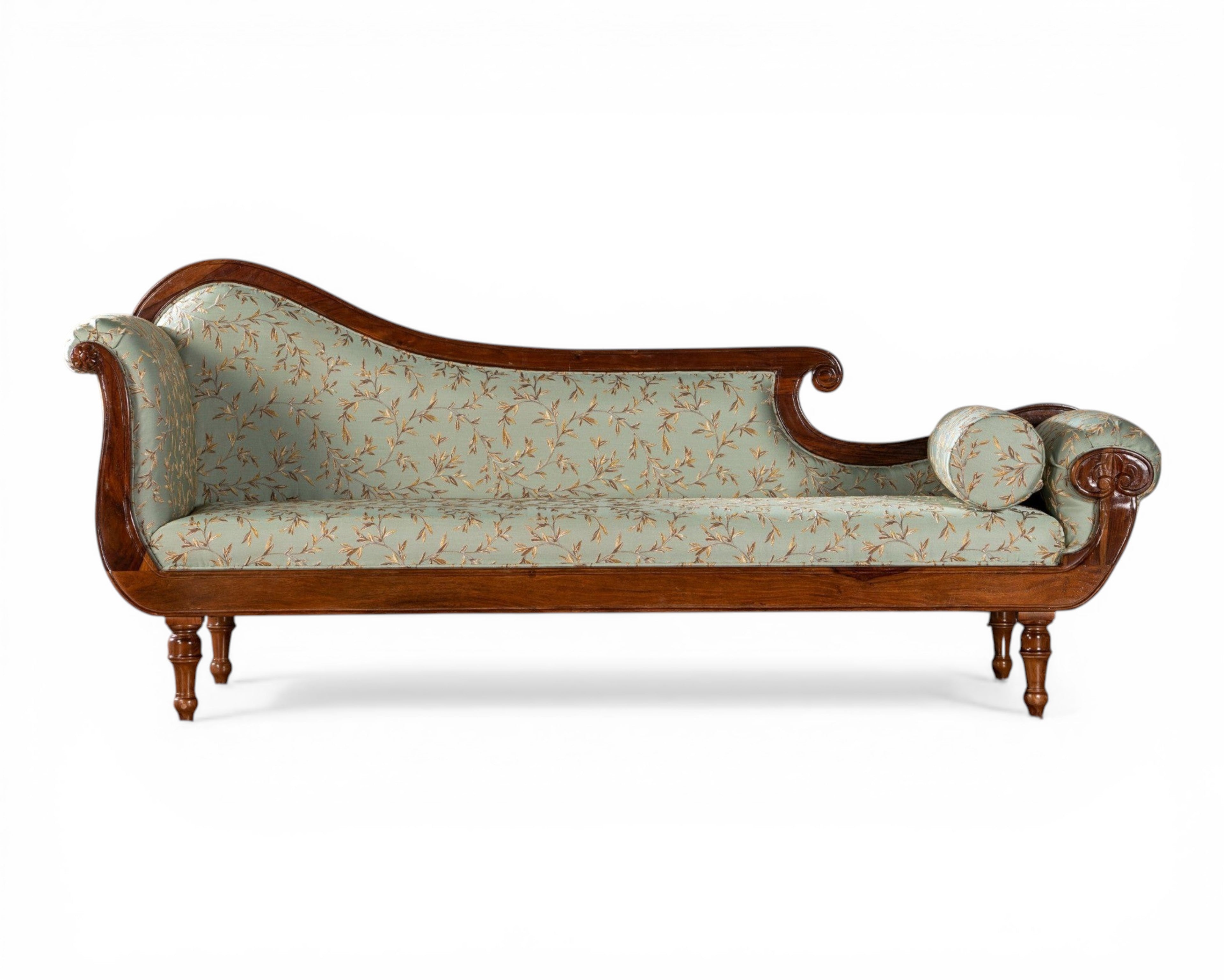 Nakoda Homes light blue floral fabric chaise lounge with wooden frame and ornate detailing.