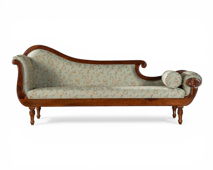 Nakoda Homes light blue floral fabric chaise lounge with wooden frame and ornate detailing.