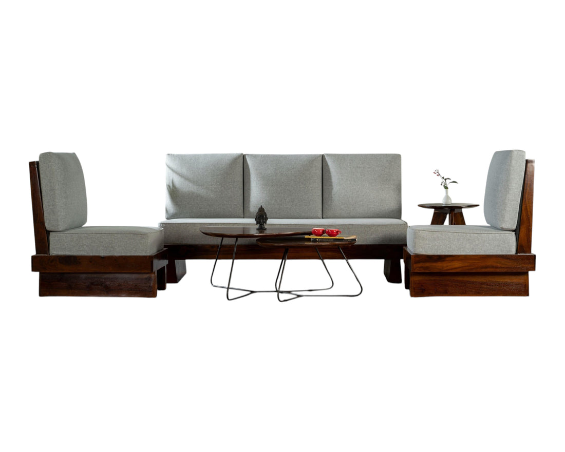 Nakoda Homes modern three-seater sofa with light grey upholstered cushions and a rich-toned wooden frame. Minimalist design.