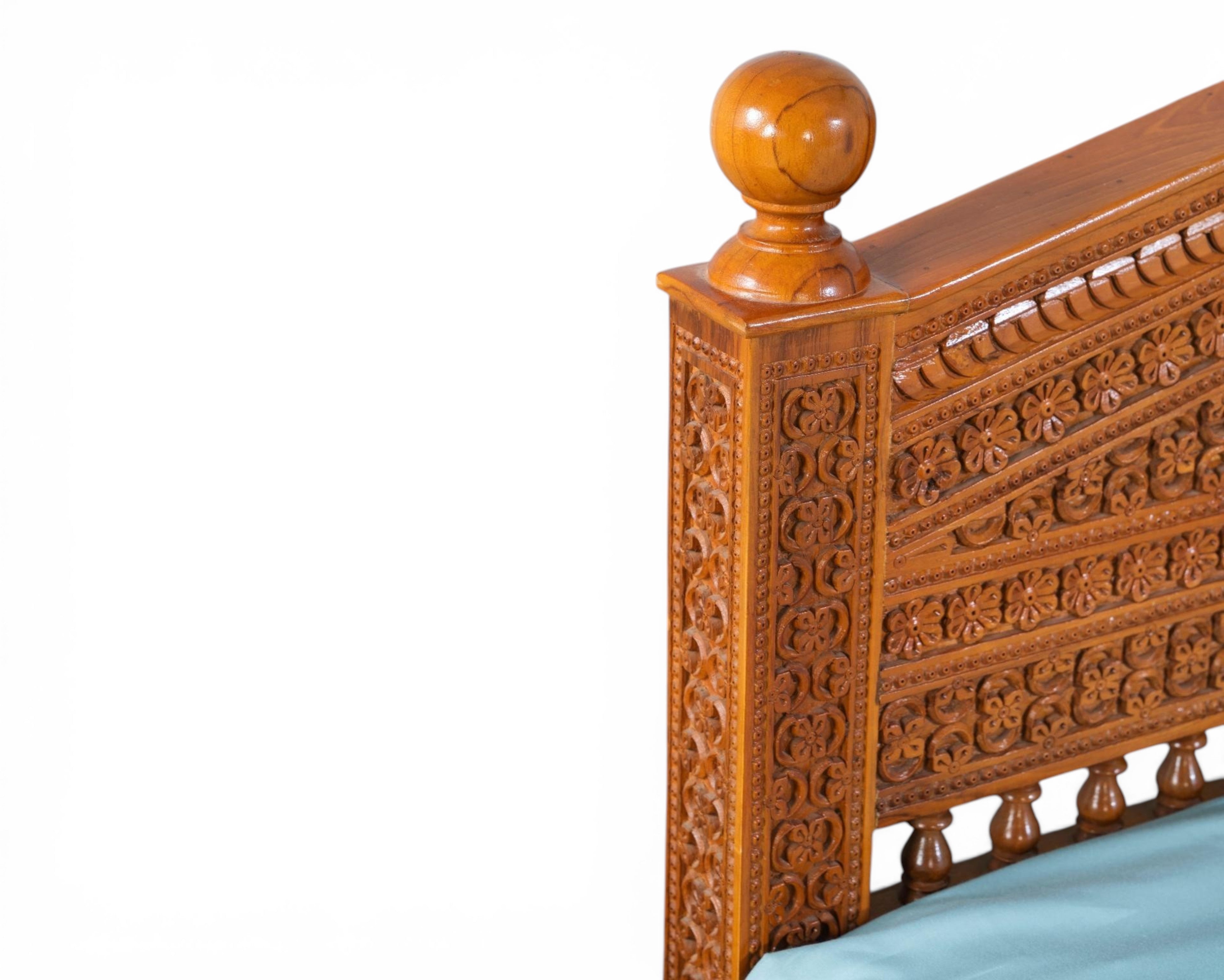 Nakoda Homes ornate carved wooden bed frame with intricate floral details and a warm wood finish.