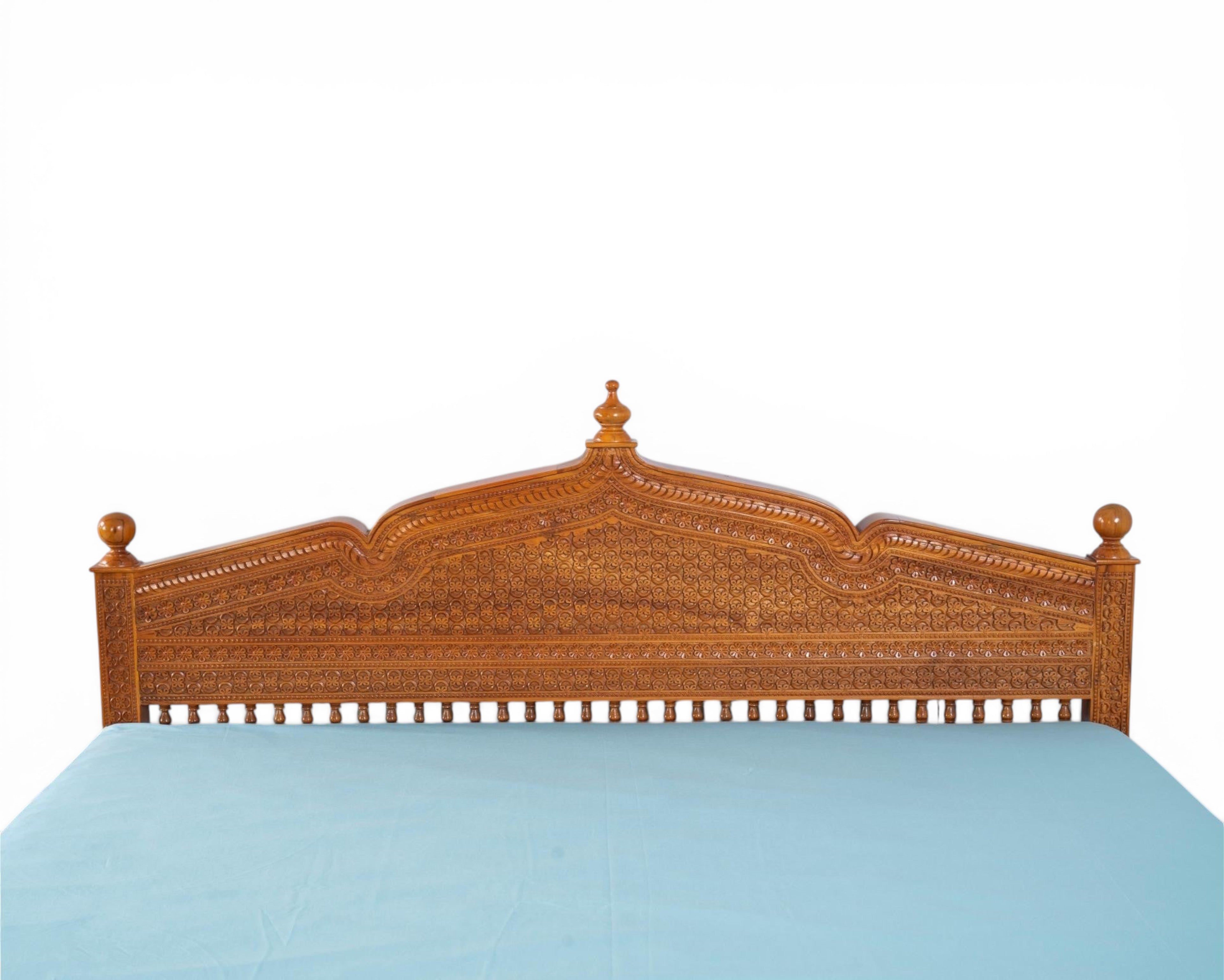 Nakoda Homes ornate carved wooden bed frame with intricate details and warm wood finish. Traditional craftsmanship.