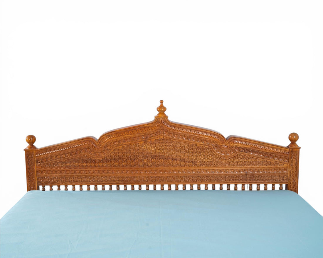 Nakoda Homes ornate carved wooden bed frame with intricate details and warm wood finish. Traditional craftsmanship.