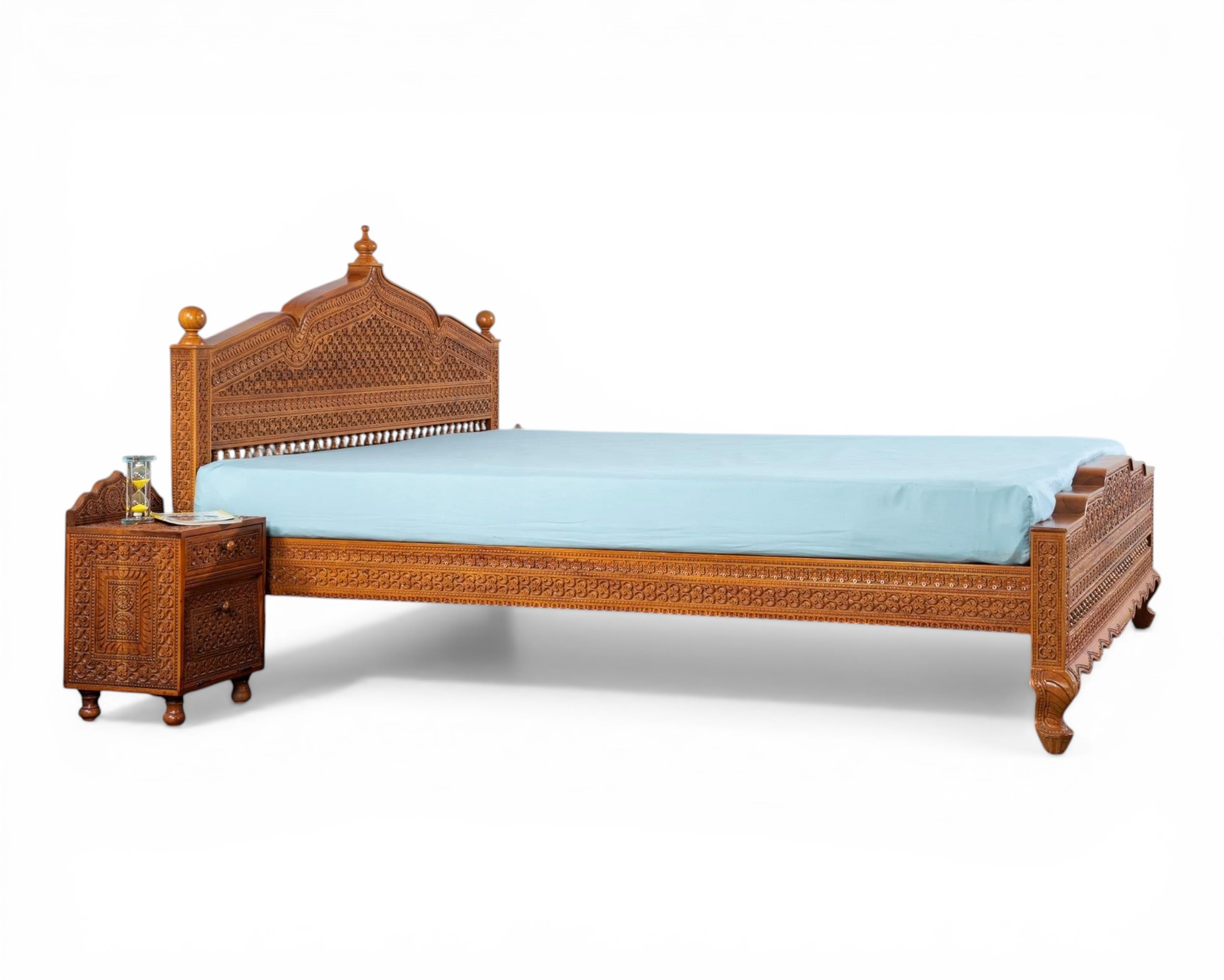 Nakoda Homes ornate carved wooden bed frame with intricate details and warm wood finish. Traditional craftsmanship.