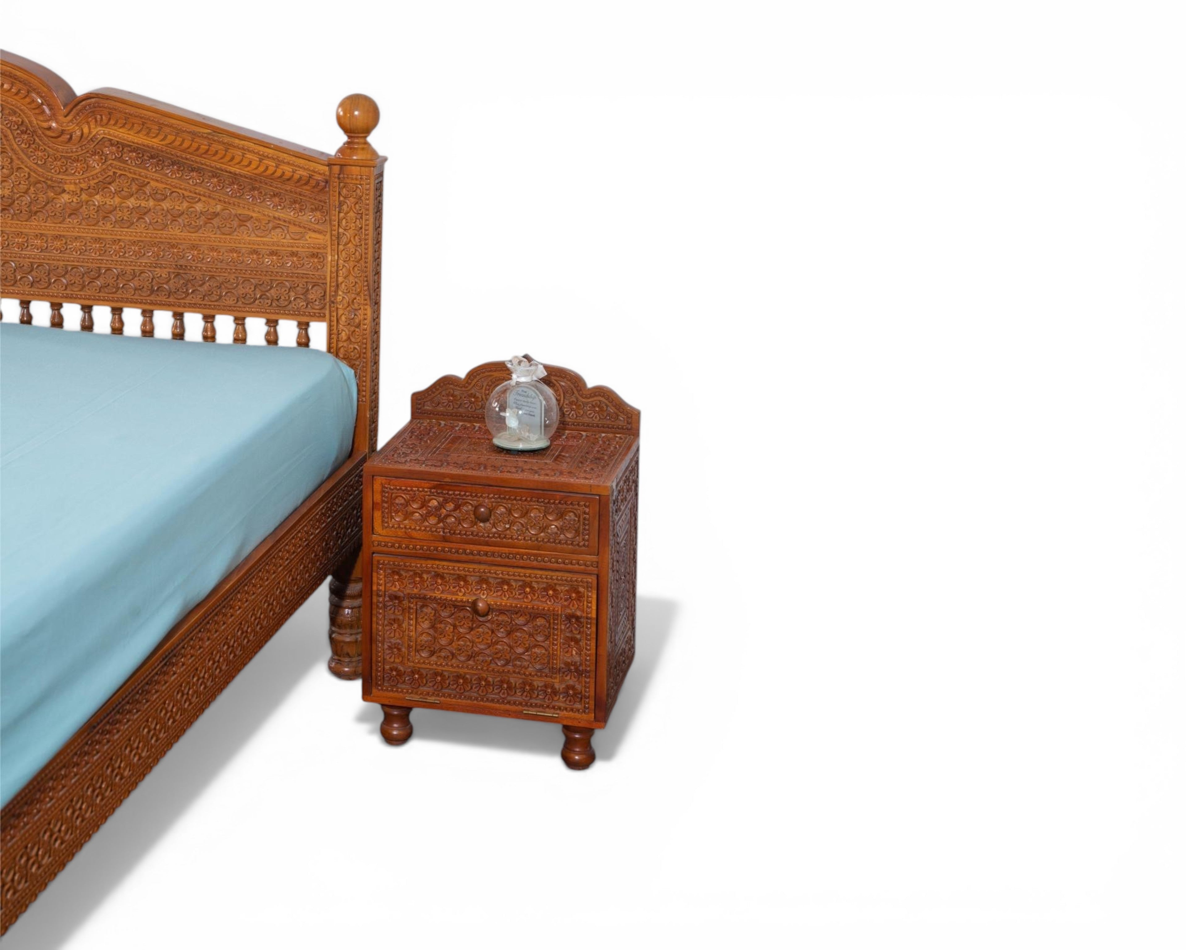 Nakoda Homes ornate carved wooden bed frame with intricate details and warm wood finish. Traditional craftsmanship.