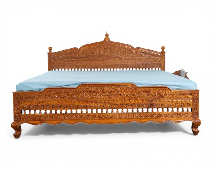 Nakoda Homes ornate carved wooden bed frame with intricate details and warm wood finish. Traditional craftsmanship.