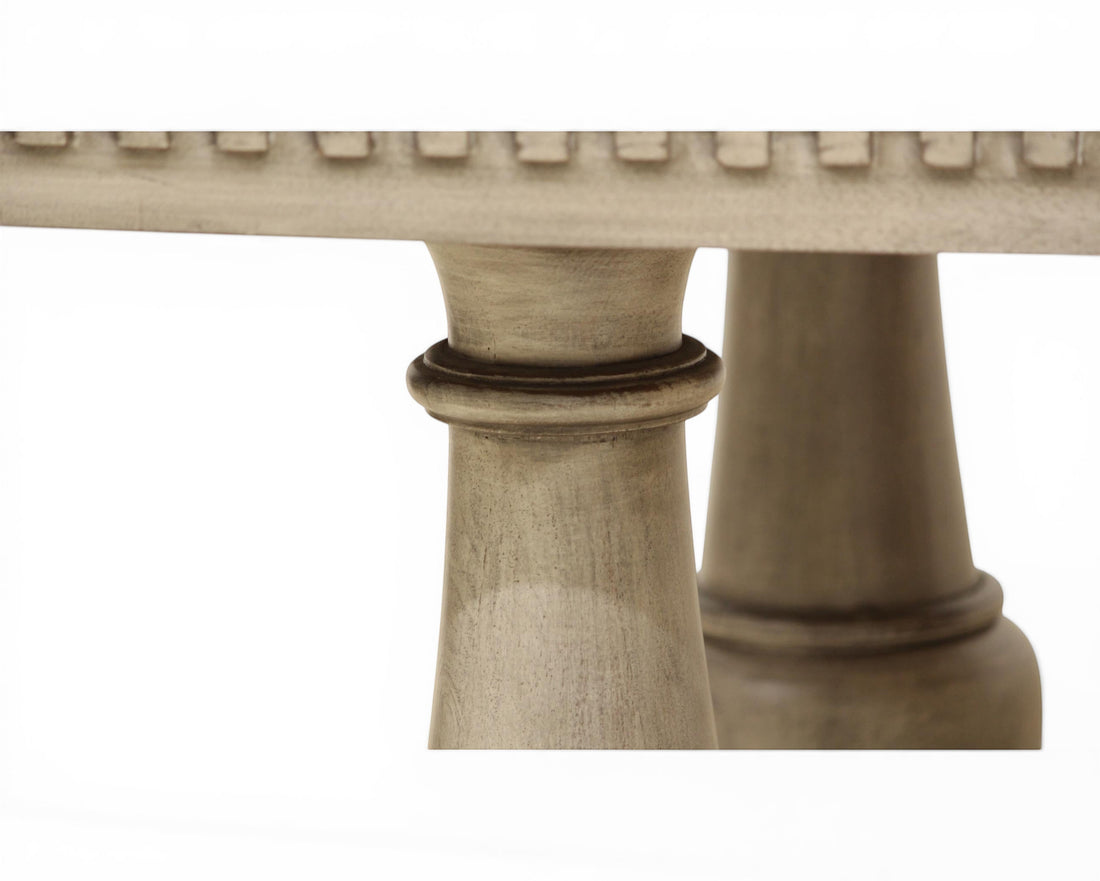 Nakoda Homes ornate grey wood pedestal dining table with carved edge and decorative base.