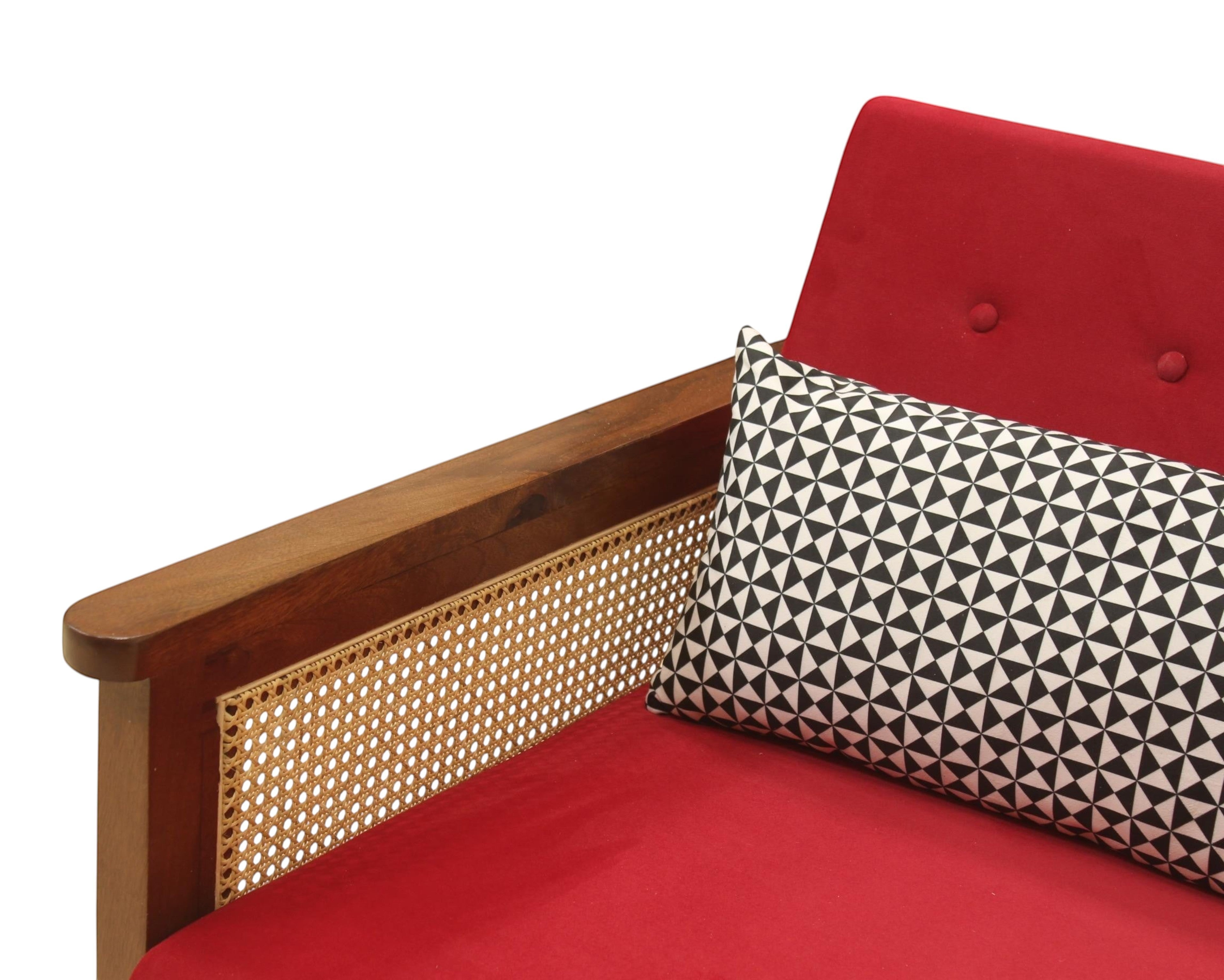 Nakoda Homes red armchair with wooden frame, cane detailing, and geometric accent pillow.