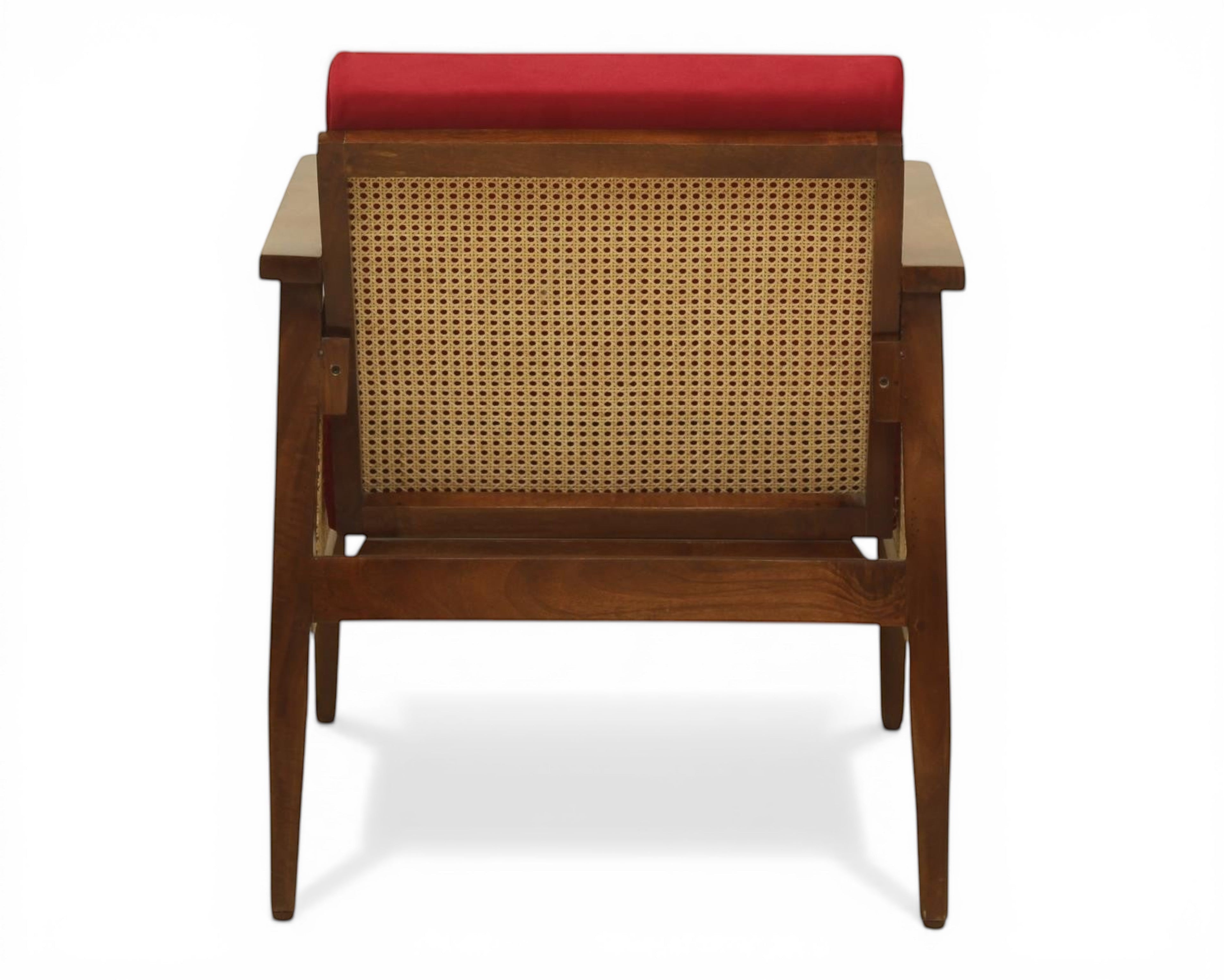 Nakoda Homes classic armchair with red upholstery, wooden frame, and cane back. Includes accent pillows.