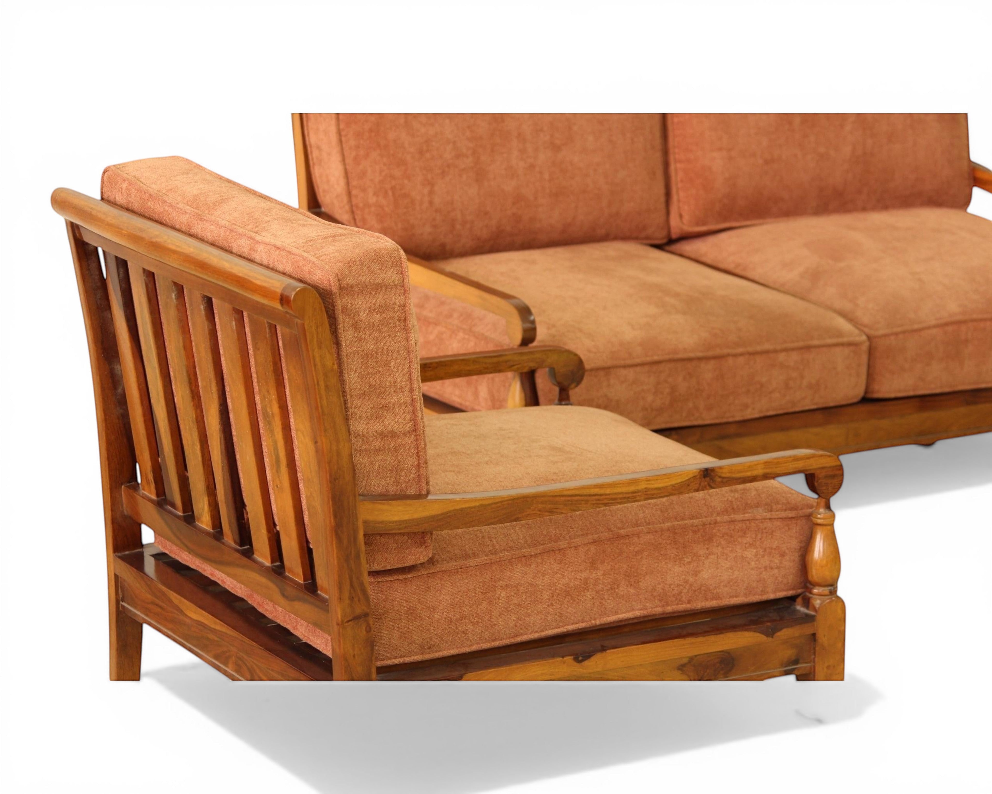 Nakoda Homes elegant rust-colored upholstered sofa and armchair set with wooden frame and tan lumbar pillows.
