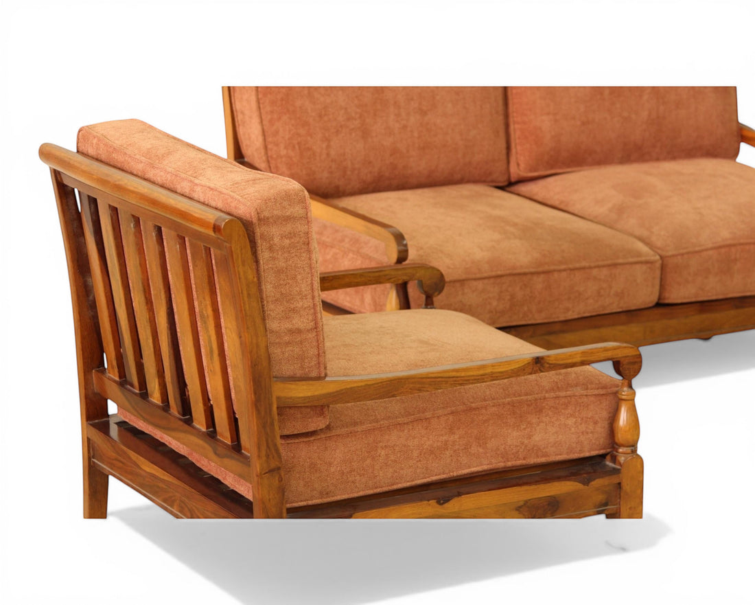Nakoda Homes elegant rust-colored upholstered sofa and armchair set with wooden frame and tan lumbar pillows.