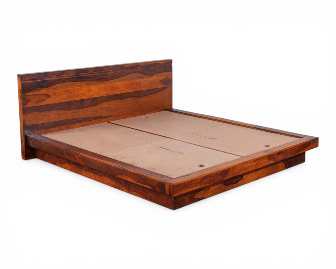 Nakoda Homes solid Sheesham wood platform bed frame with minimalist headboard and natural grain. Low-profile modern design.