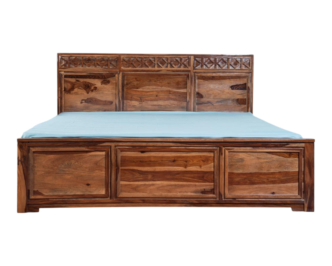 Nakoda Homes Sheesham wood bed frame with carved geometric headboard and storage drawers. Rich natural wood grain.
