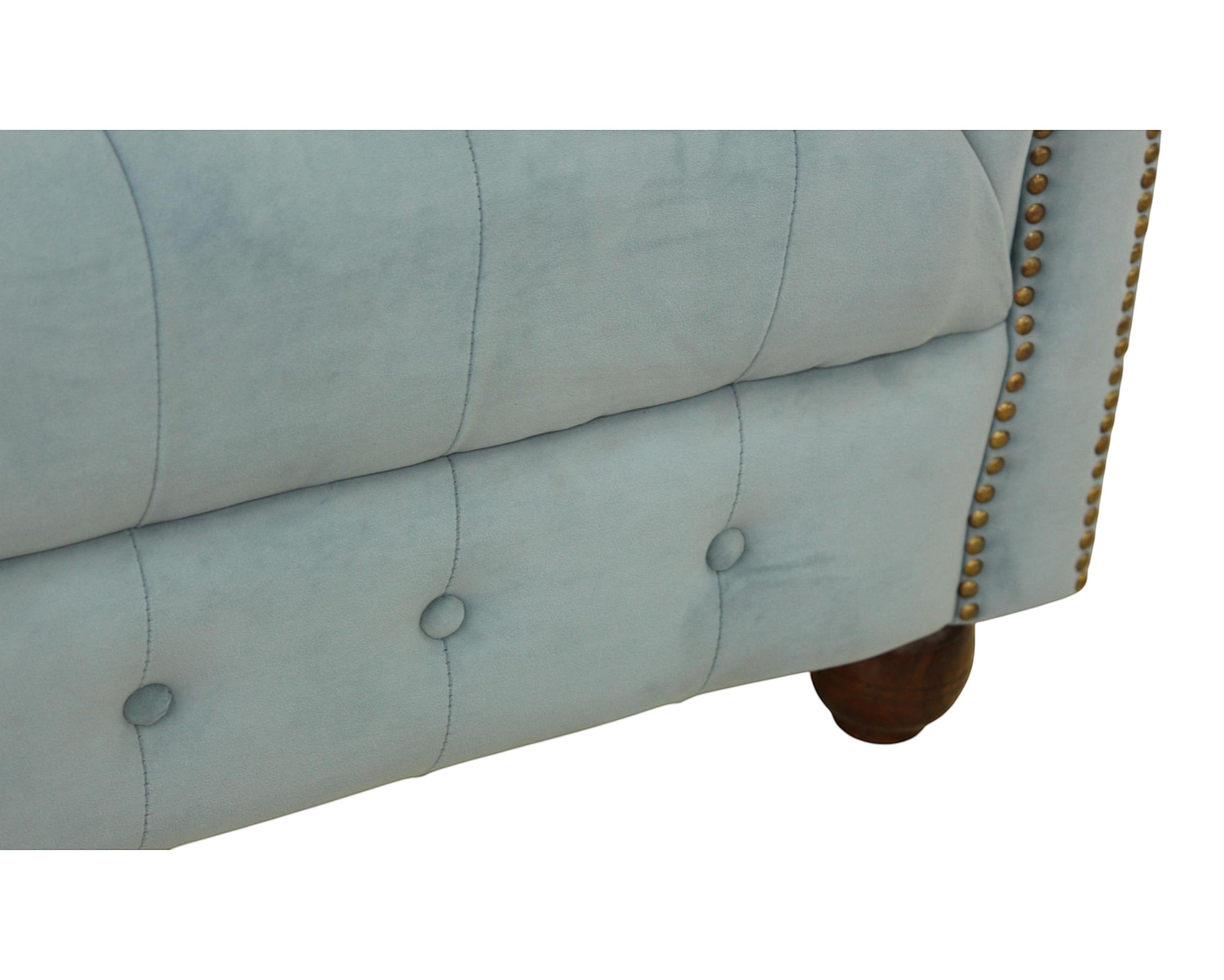 Nakoda Homes sky blue velvet Chesterfield sofa with button tufting and brass nailhead trim. Features dark wood legs.