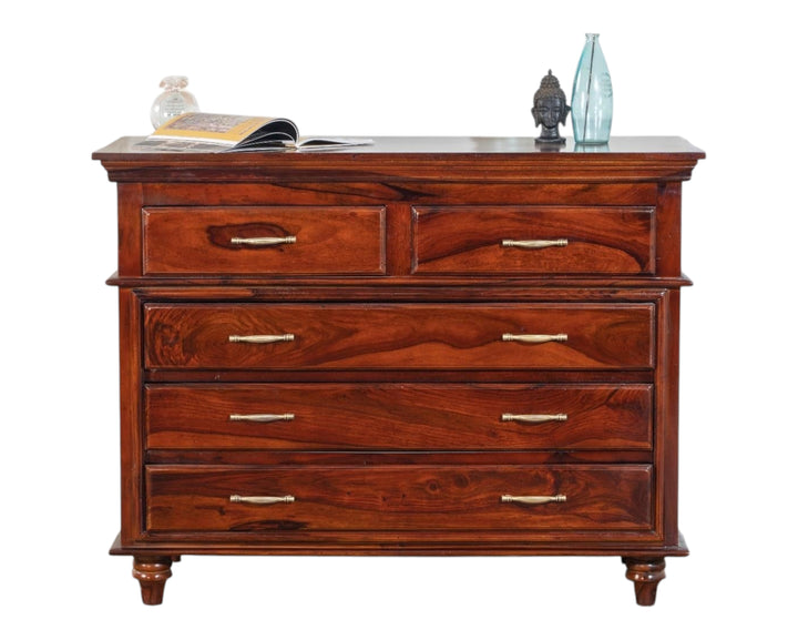 Nakoda Homes classic solid wood chest of drawers in warm brown with brass hardware and turned legs.