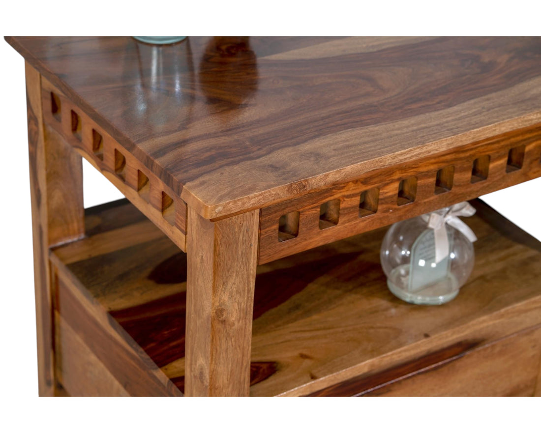 Nakoda Homes solid wood console table with two drawers and carved detailing. Warm wood tones and visible grain.