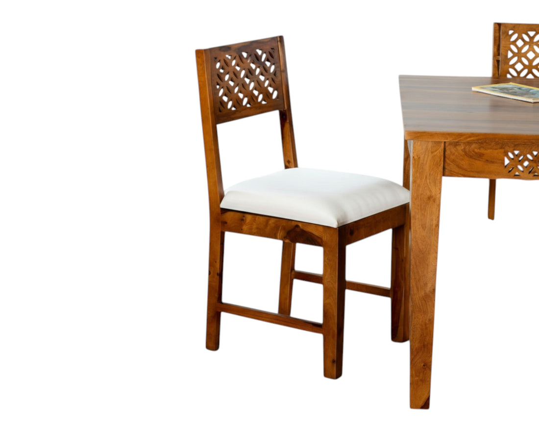 Nakoda Homes solid wood dining set with white cushioned seats and intricately carved chair backs and table apron.