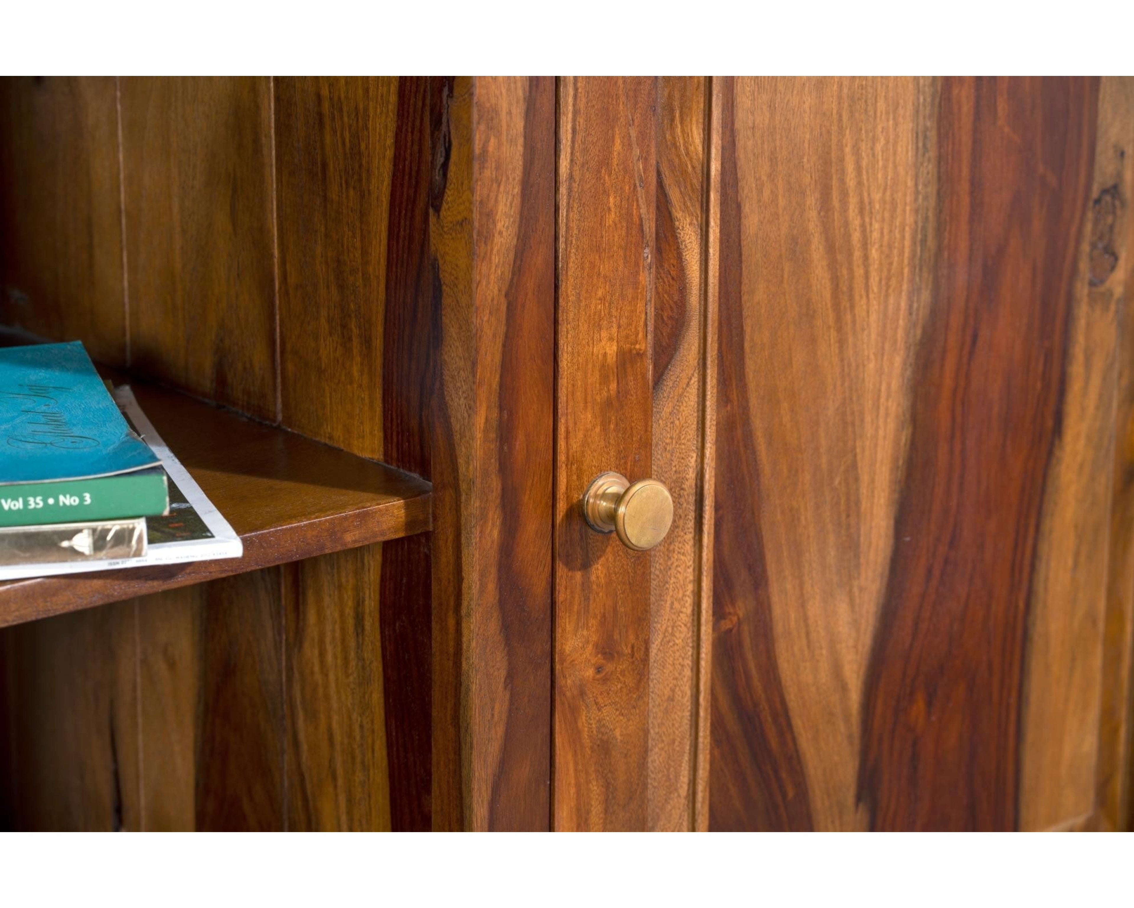 Nakoda Homes solid Sheesham wood media console with brass knob, featuring cabinet storage and open shelf. Rustic wood grain.