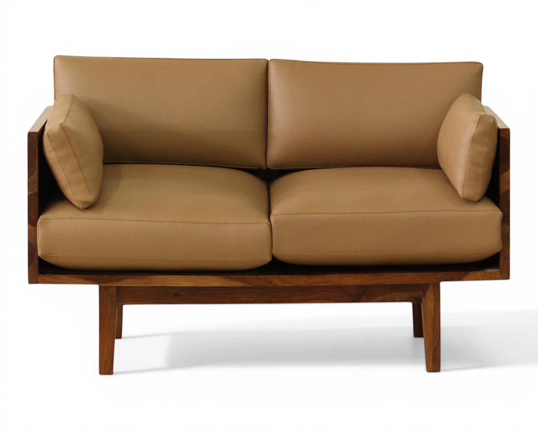 Nakoda Homes modern tan upholstered three-seater sofa with warm wood frame and clean lines.