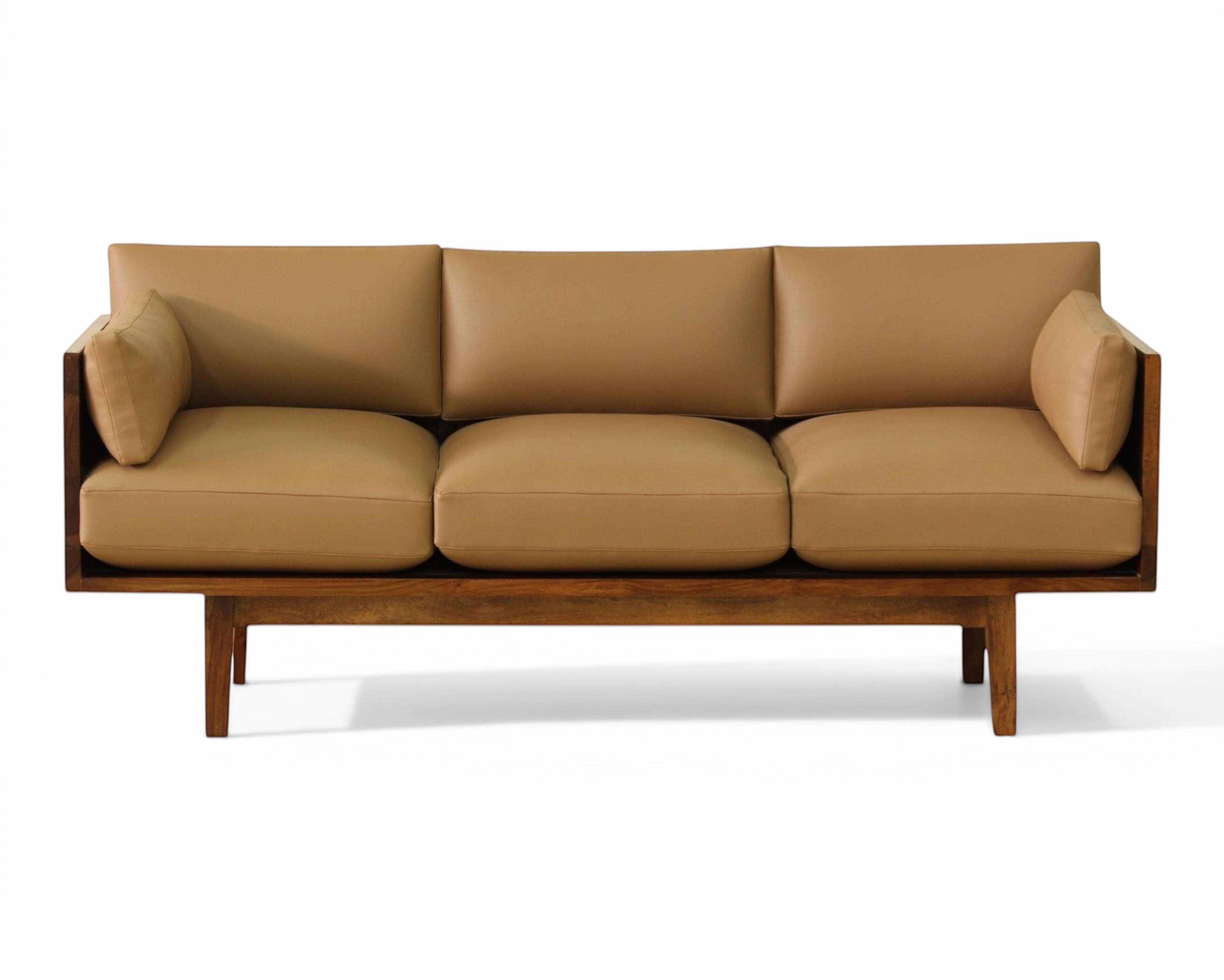Nakoda Homes tan upholstered three-seater sofa with warm wood frame and minimalist design.