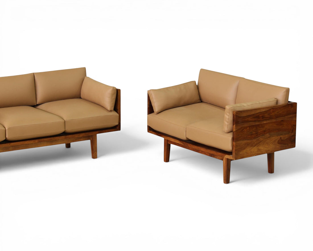 Nakoda Homes modern three-seater sofa with plush tan upholstery and warm wood frame. Clean lines, minimalist design.